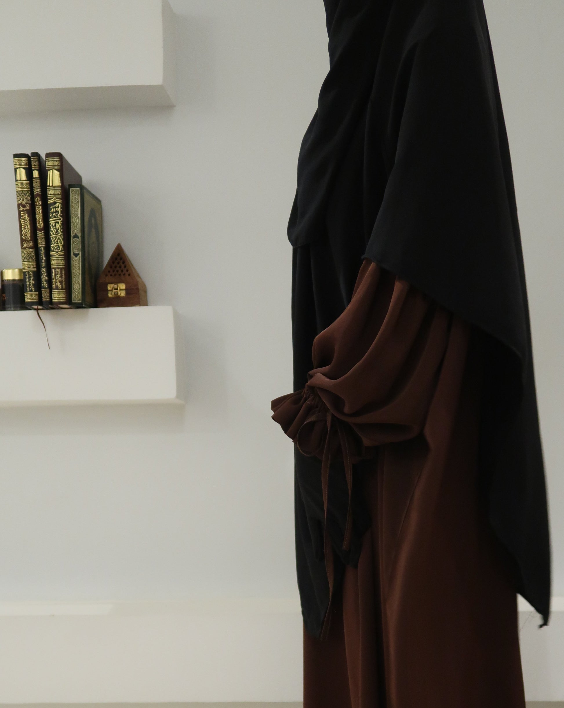 Brown fabric draped over a white surface with a blurred background