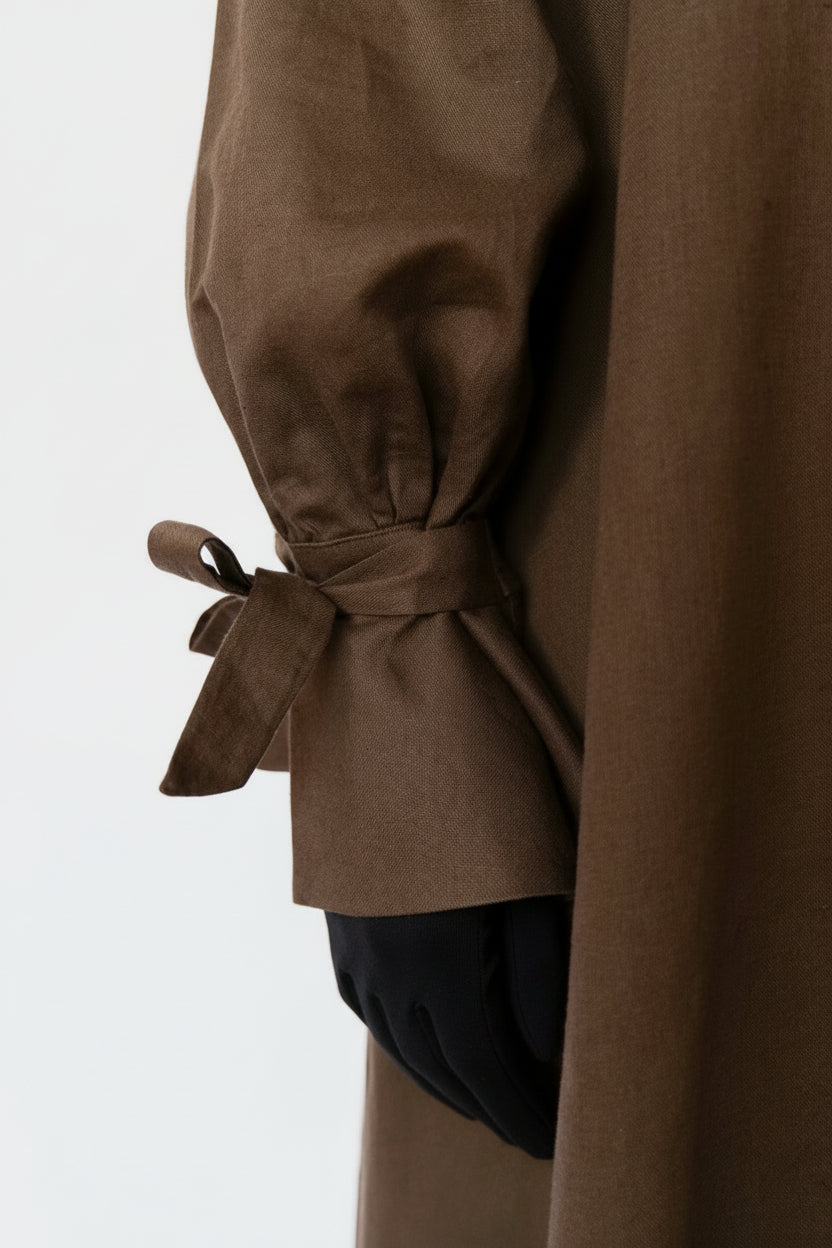 Brown abaya with tied sleeves on a white background