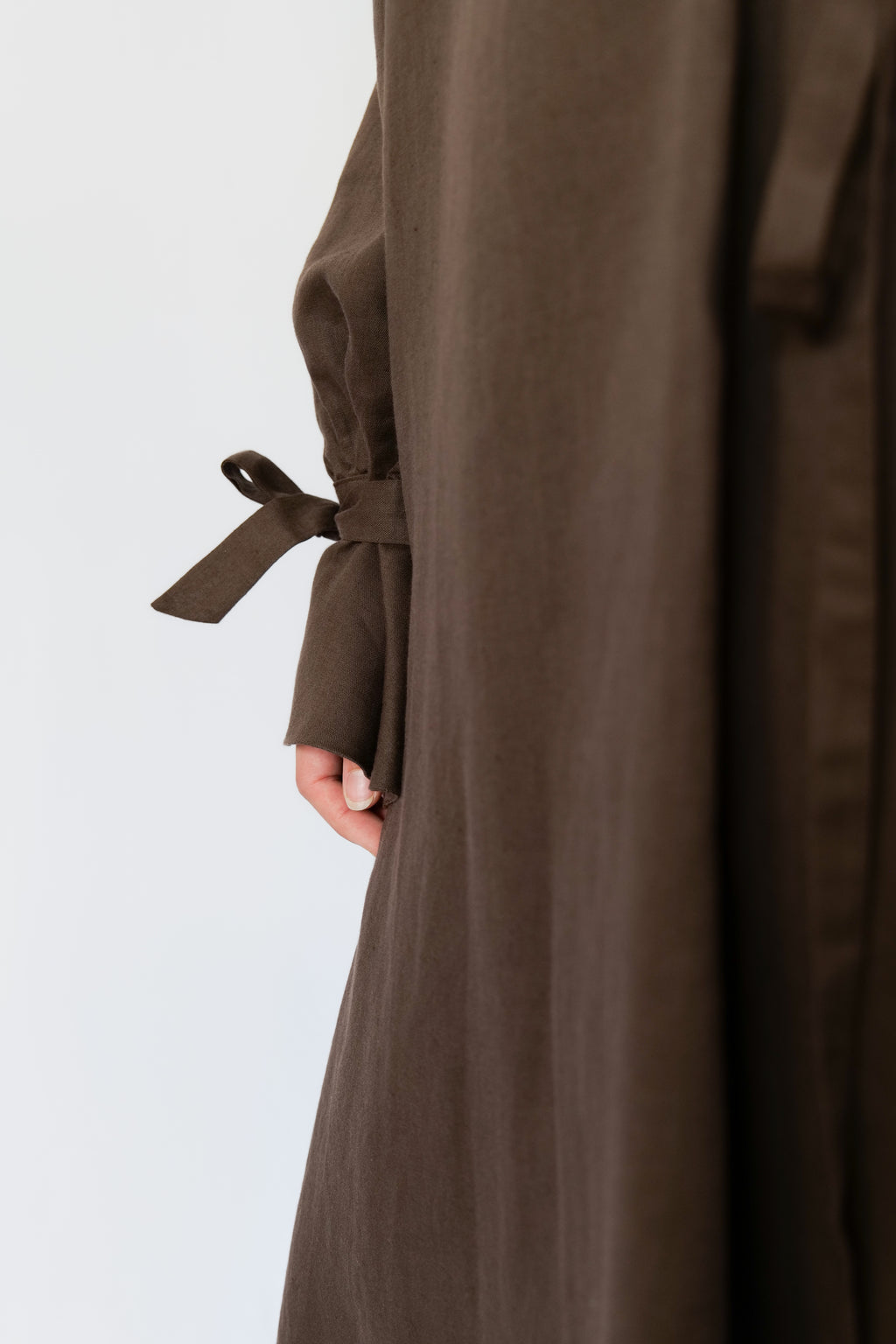 Brown abaya with a belt on a light gray background