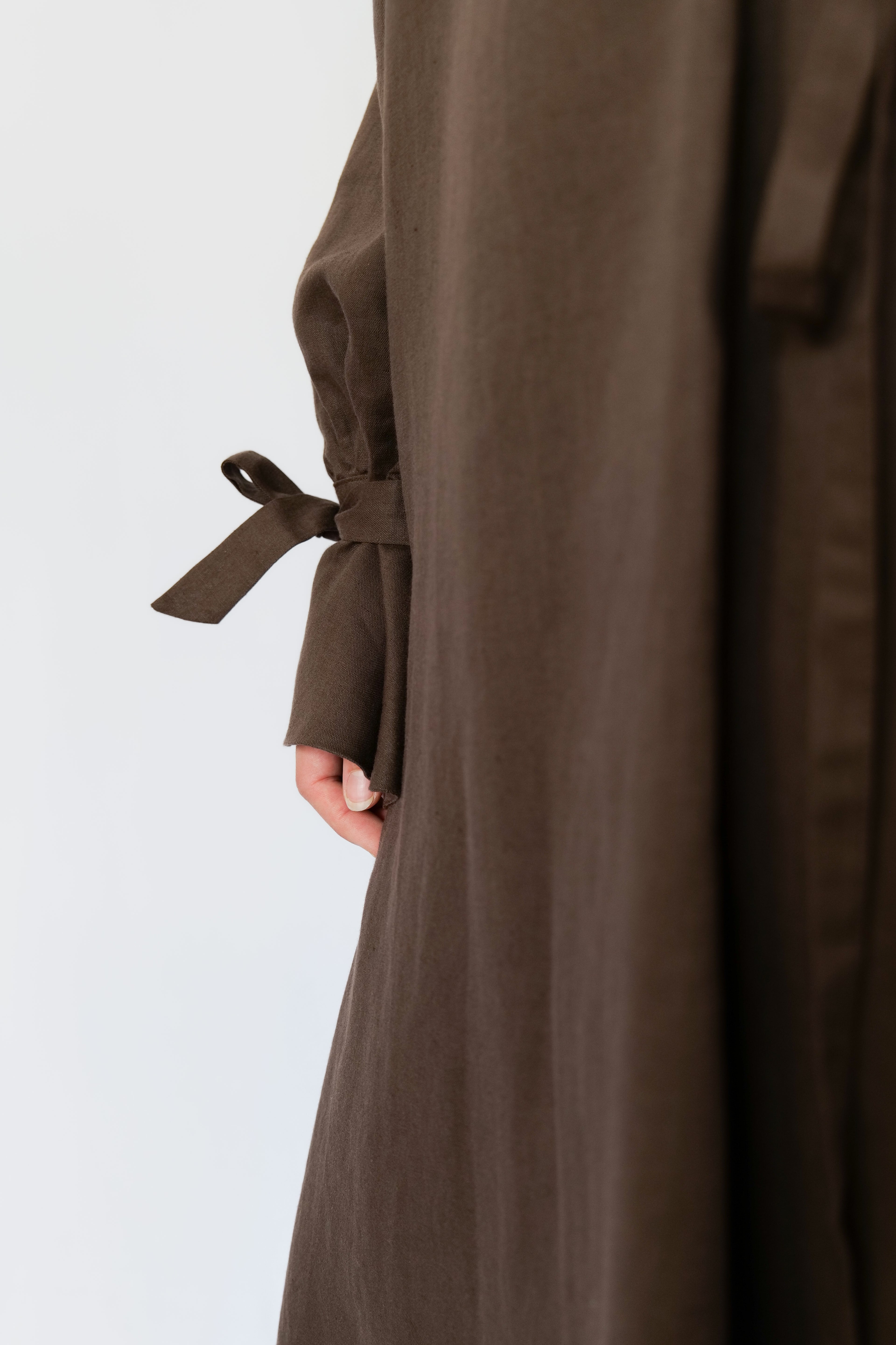 Brown abaya with a belt on a light gray background